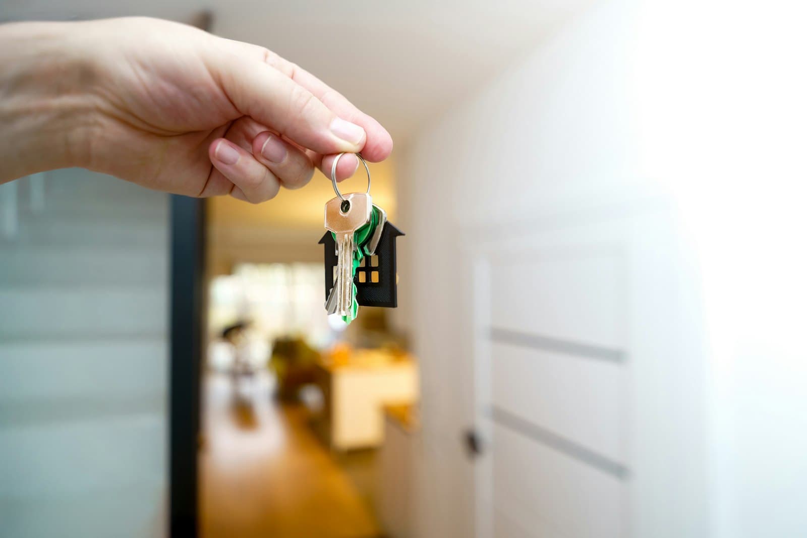 House keys being handed over in the doorway of a new home