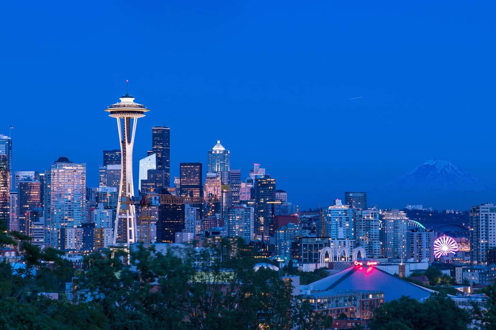 Canadian couple reviewing property plans while preparing to buy property in Washington with a Seattle skyline in the background.